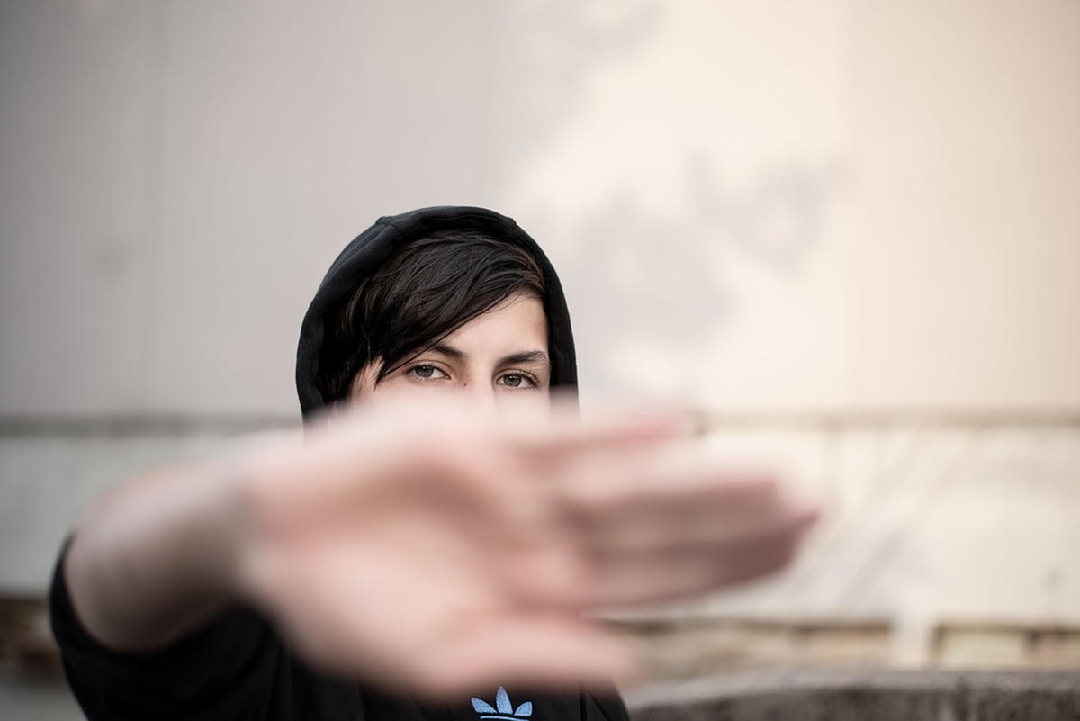 vrouw houdt hand op, symboliseert afwijzing en emotionele bescherming