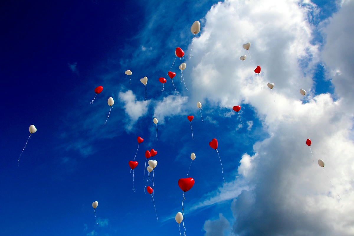 rode en witte hartvormige ballonnen die de lucht in stijgen als symbool van liefde en authentieke verbindingen