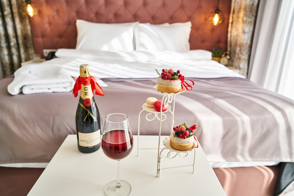 Romantische hotelkamer met champagne, desserts en een glas wijn – symbool voor liefde, intimiteit en verbinding.