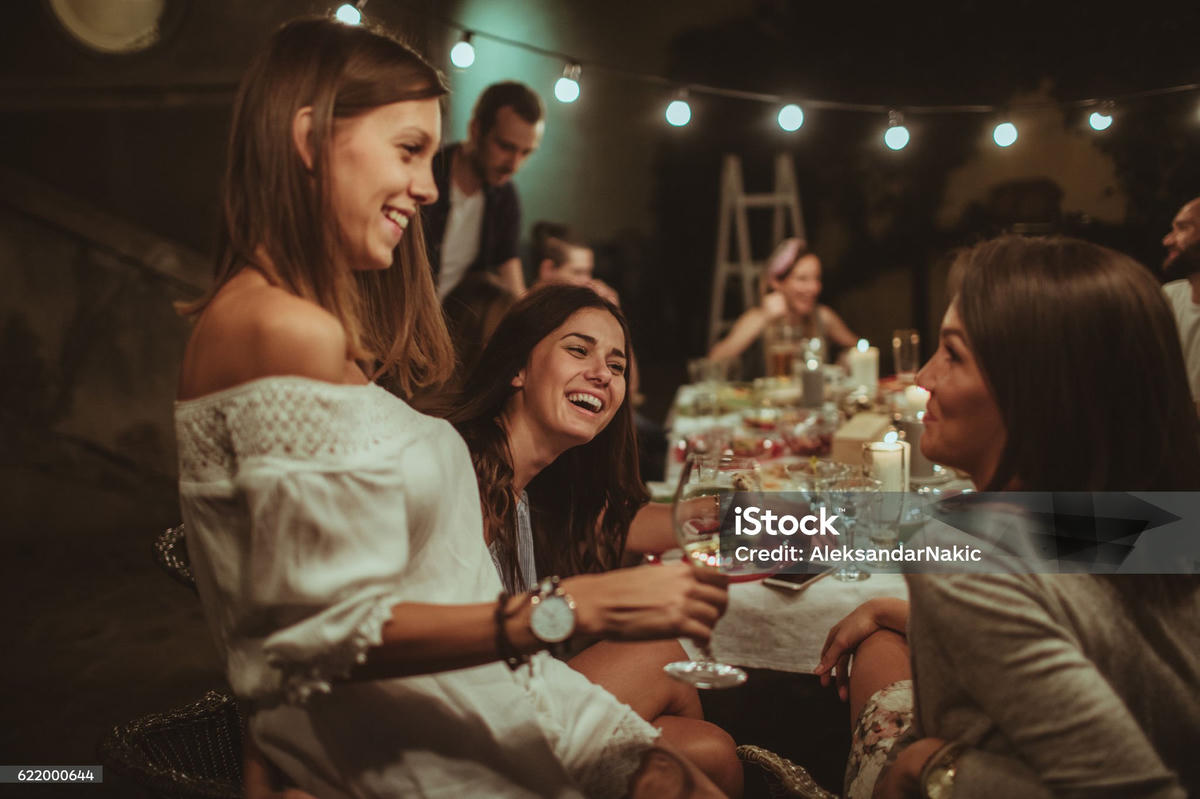 vrouwen lachen tijdens een gezellig diner en voeren diepgaande gesprekken